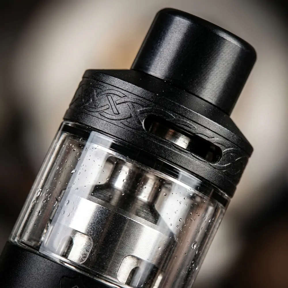 Close extremo do Dead Rabbit R Tank Hellvape mostrando metal, vidro, roscas e micro-reflexos com condensação - Vapor Gringo