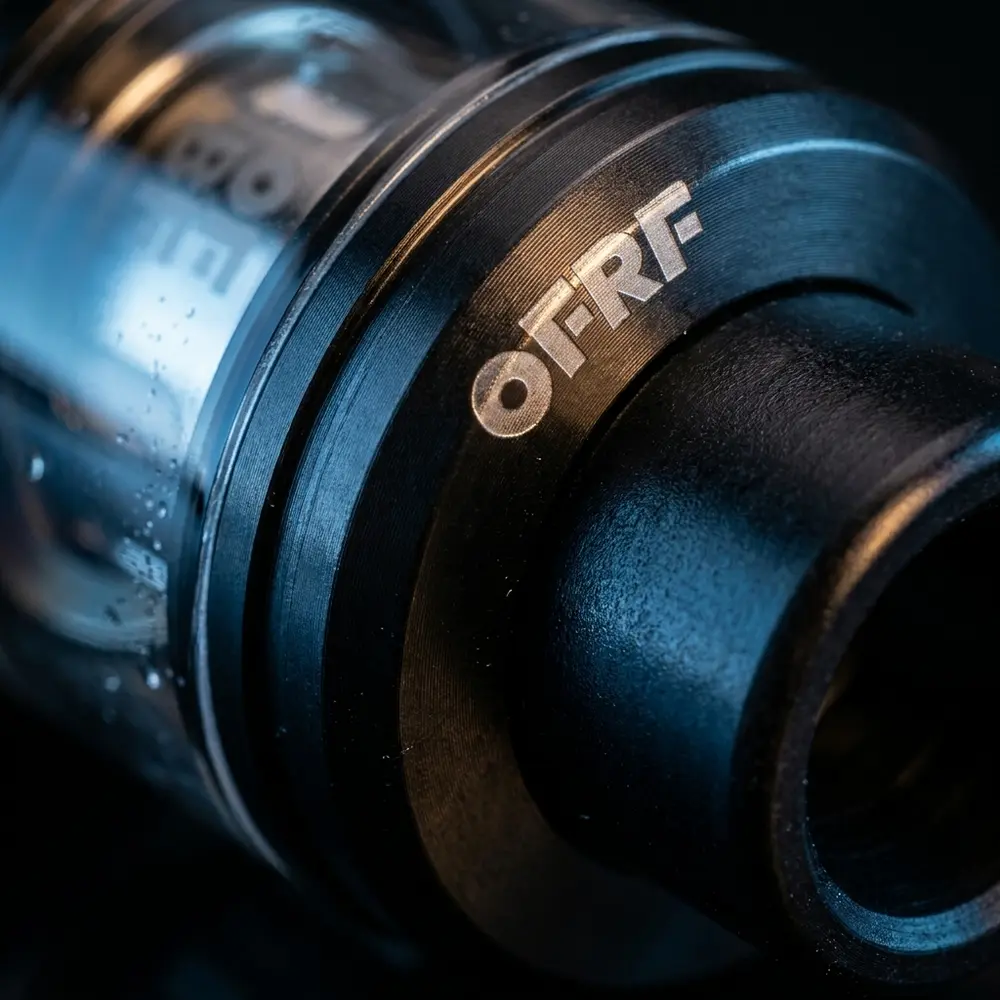 Detalhe macro do atomizador nexMESH 25mm OFRF mostrando metal, vidro, ponta 810 e micro-condensacao - Vapor Gringo