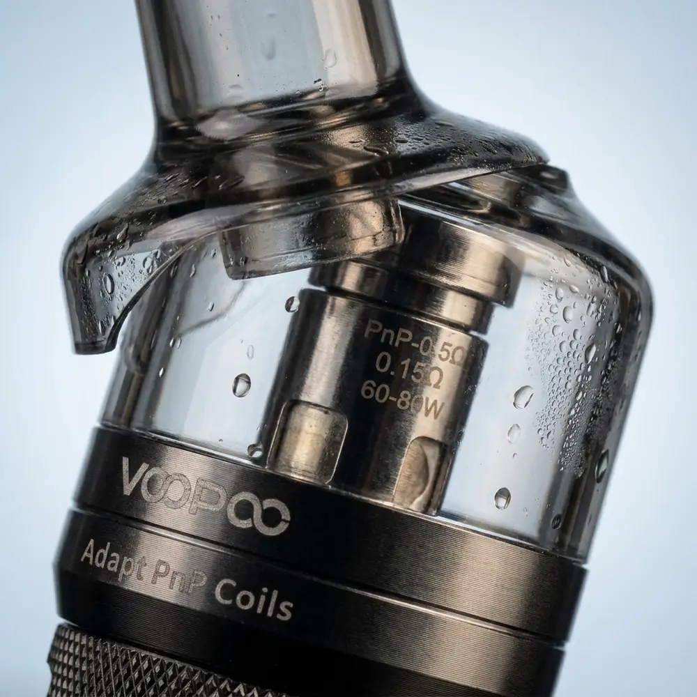 Detalhe do Atomizador PNP Pod Tank Voopoo mostrando boquilha, vidro e textura metálica com gotículas visíveis - Vapor Gringo