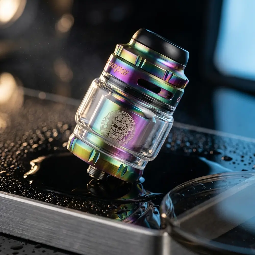Atomizador Zeus X 2 Mesh RTA suspenso sobre acrilico preto com gotas e reflexos metalicos dramaticos - Vapor Gringo