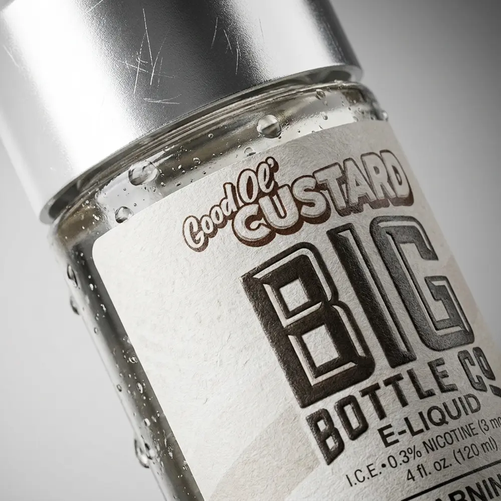 Close macro do rotulo e bocal do frasco Big Bottle Co. Good Ol' Custard 120ml com gotas de condensacao e reflexos metalicos - Vapor Gringo