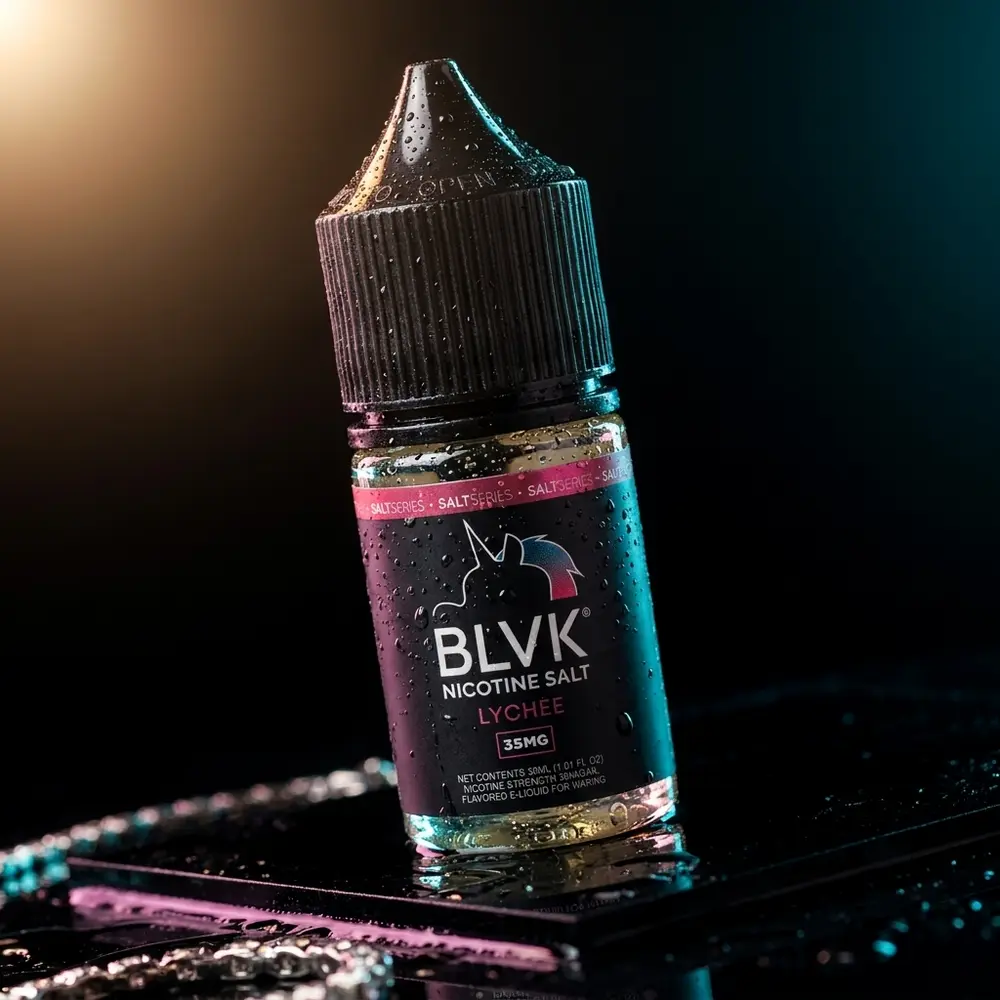 Garrafa de liquido BLVK Unicorn Lychee sobre acrilico preto com gotas e reflexos magenta-ciano - Vapor Gringo
