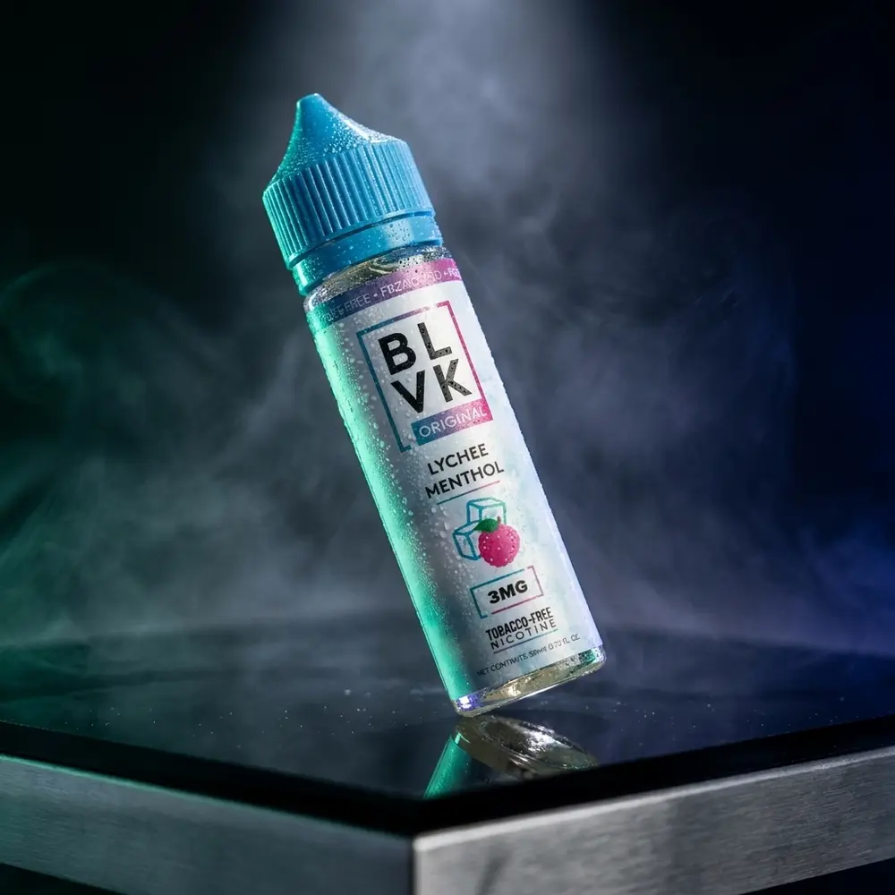 Garrafa de liquido Blvk Unicorn Lychee Menthol sobre base acrilica escura com iluminacao mint e reflexos - Vapor Gringo