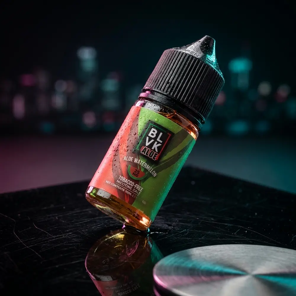 Frasco 30ml Blvk Unicorn Salt Aloe Watermelon sobre base acrílica escura, iluminação magenta/verde e gotas de condensação - Vapor Gringo