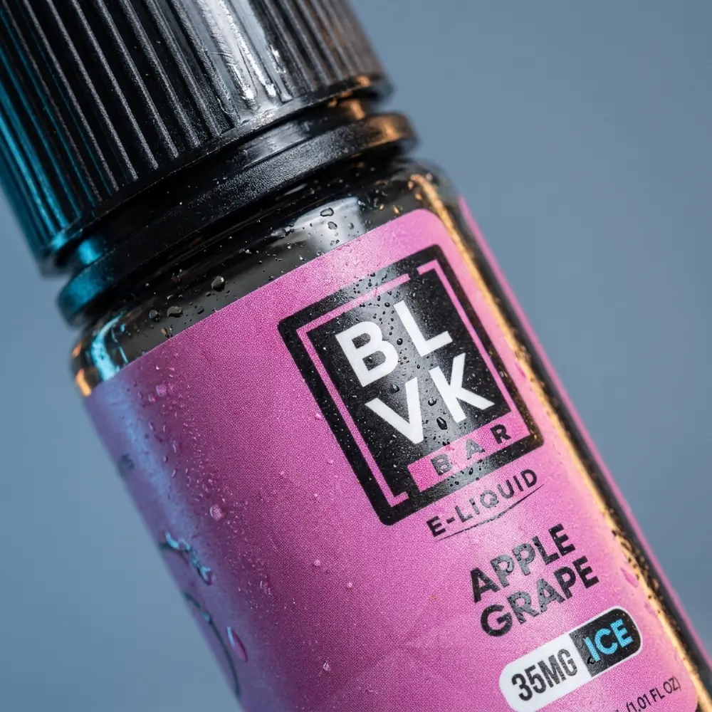Close-up do rótulo e bico da garrafa BLVK Unicorn Salt Apple Grape Ice com gotículas de condensação - Vapor Gringo