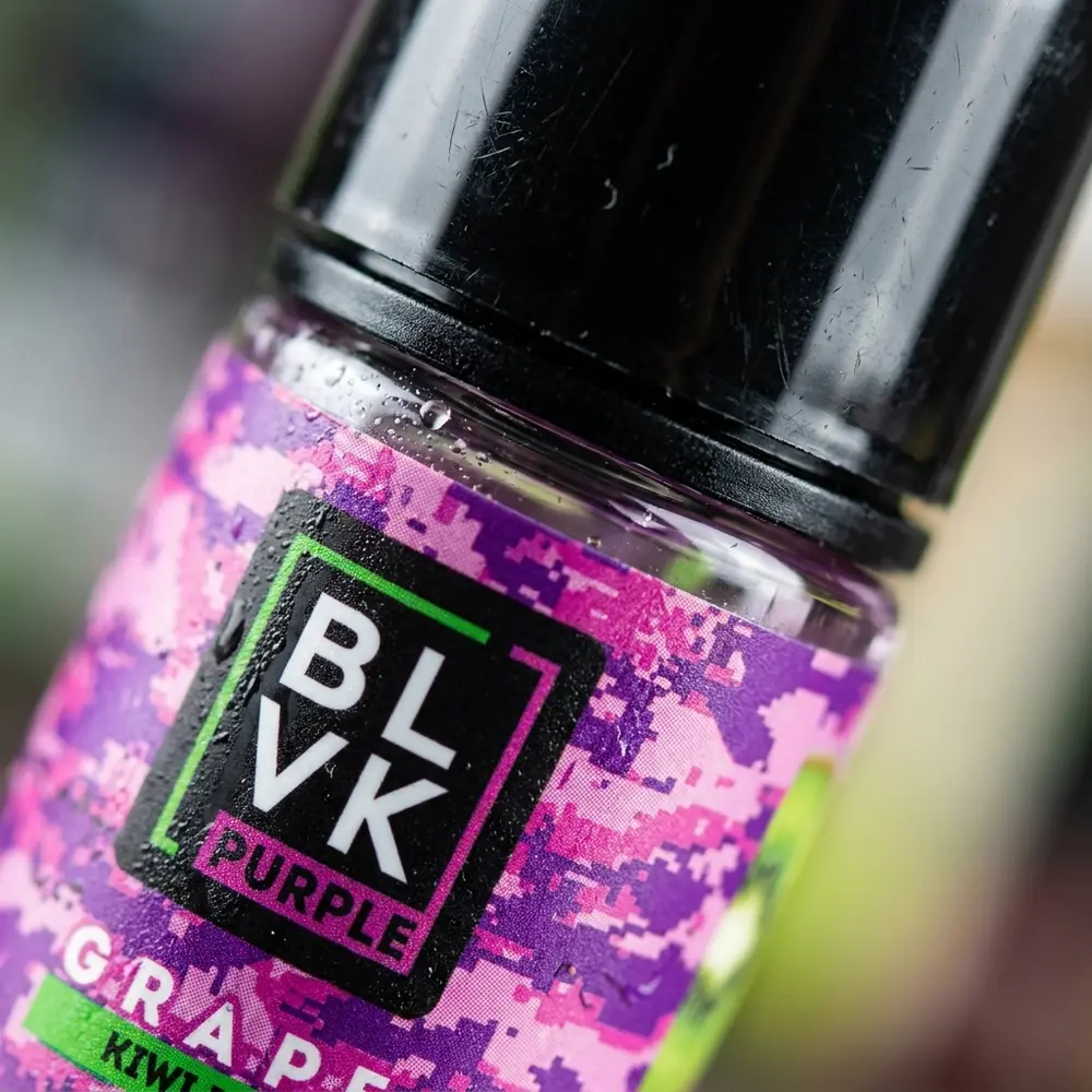 Close do rótulo Blvk Unicorn Salt com gotas, textura do papel e brilho do bico e da tampa. - Vapor Gringo