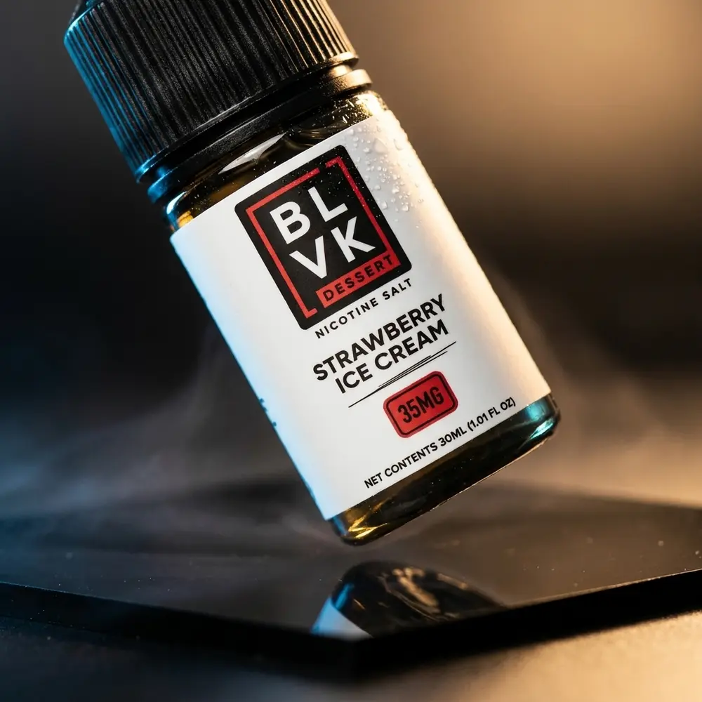 Garrafa do Liquido Blvk Unicorn Salt Strawberry Ice Cream Remix sobre base acrilica preta com luz dramática - Vapor Gringo