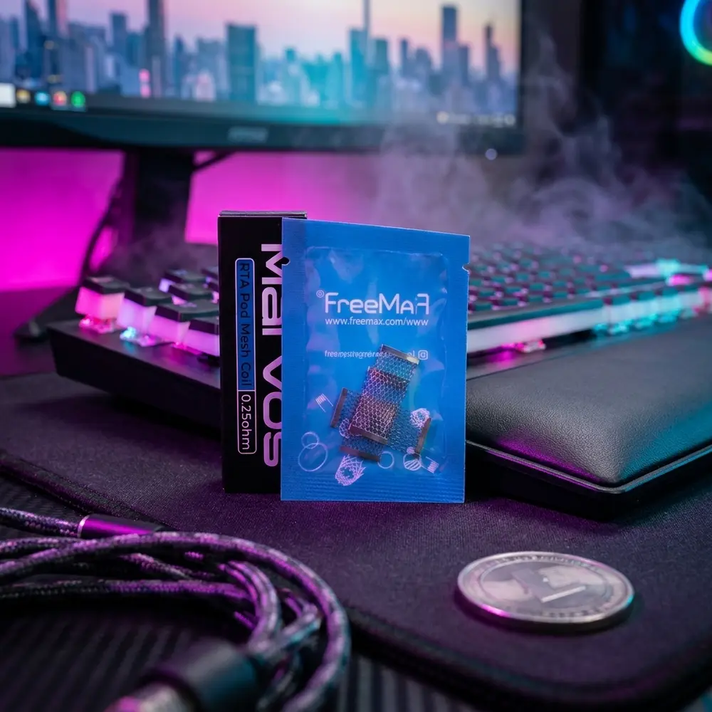 Pack Bobina RTA Mesh Marvos Freemax em mesa gamer RGB ao lado de teclado mecanico e reflexos neon - Vapor Gringo