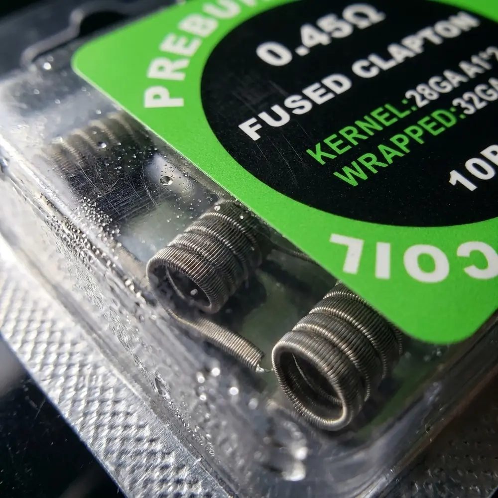 Detalhe do fio Fused Clapton 0,45ohm mostrando enrolamento, textura metálica e gotas de condensação no blister - Vapor Gringo
