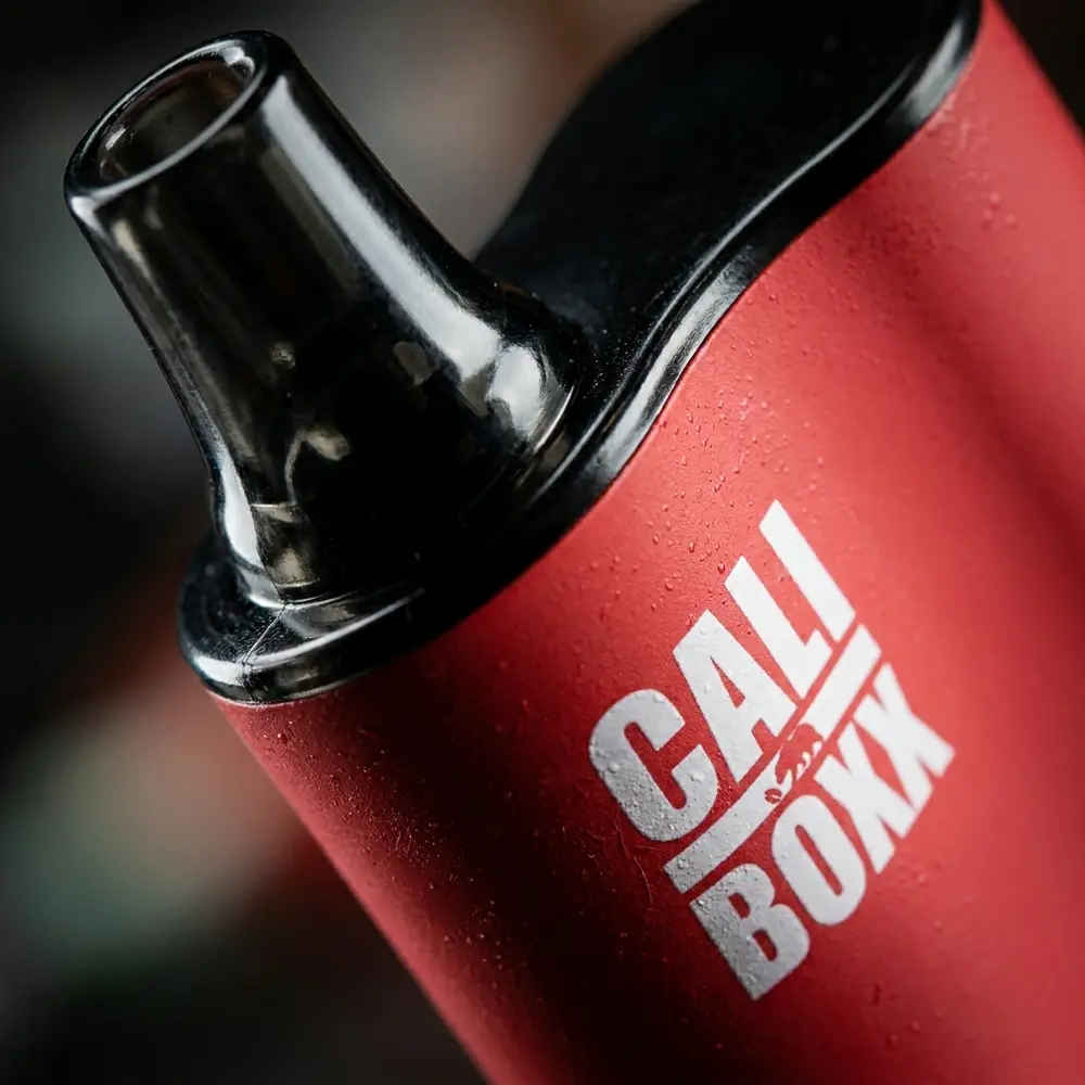 Detalhe macro do bocal e rótulo do Cali Bars Boxx melancia, textura plástica, condensação e reflexos - Vapor Gringo