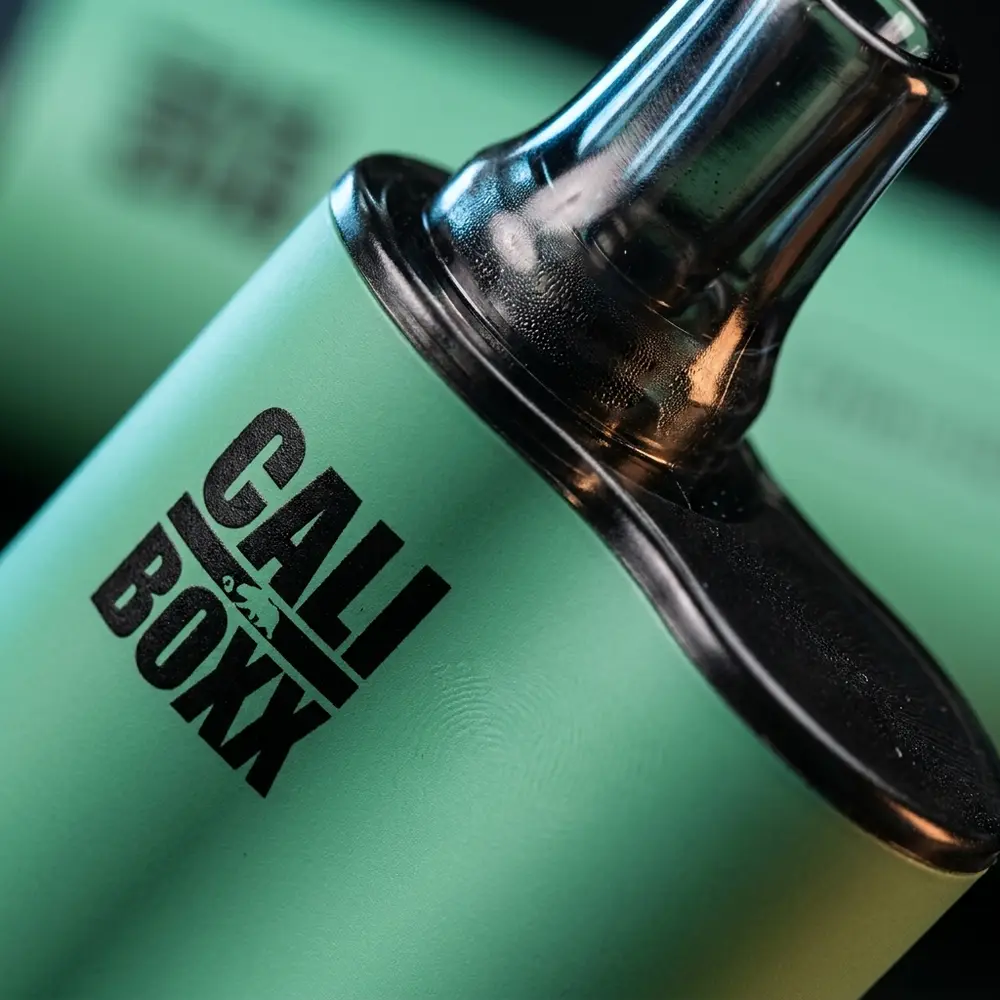 Close-up do bocal e logotipo do Cali Bars Boxx Mighty Mint com condensacao e reflexos precisos - Vapor Gringo