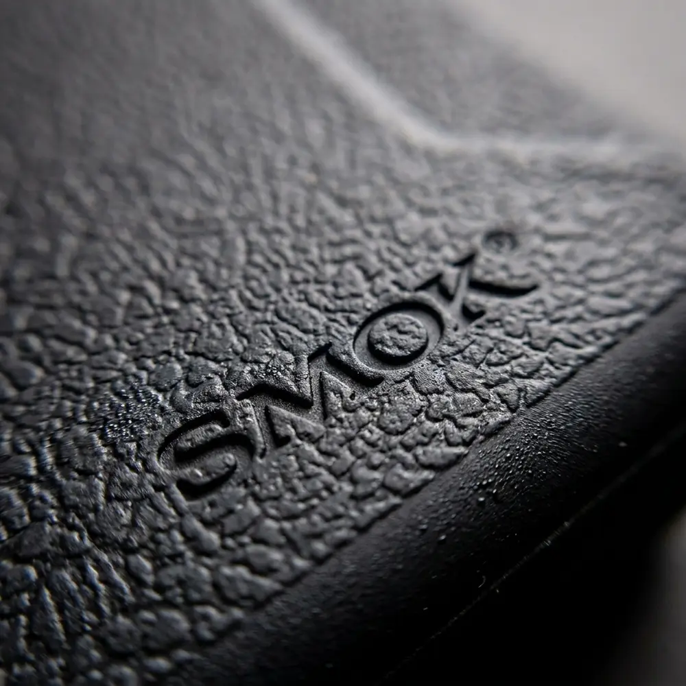 Close-up macro da textura e logo da capa de protecao H-Priv 2 Smok com gotas e reflexos subtis - Vapor Gringo