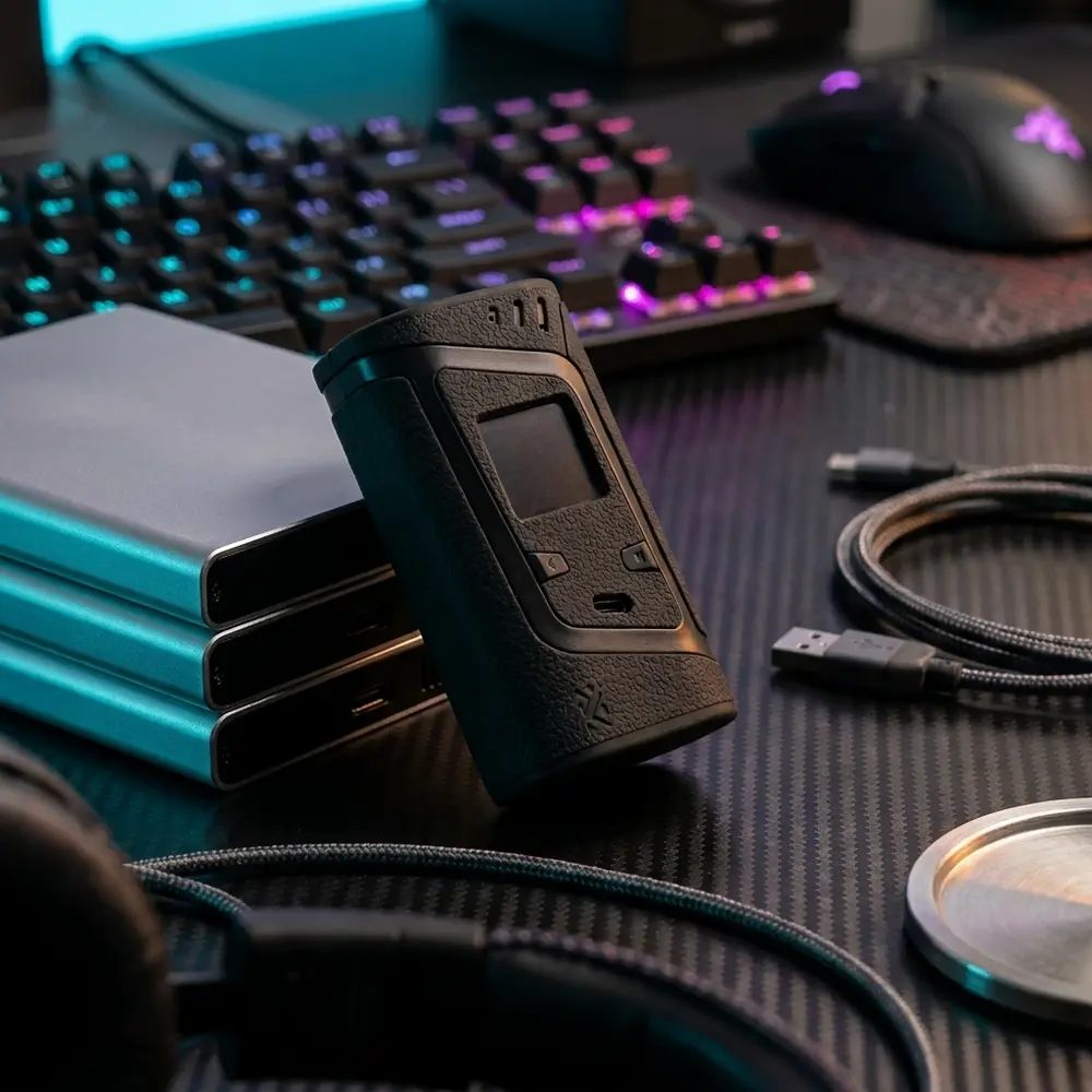 Capa protetora Alien 220w da Smok sobre mesa gamer RGB perto de teclado e mouse - Vapor Gringo