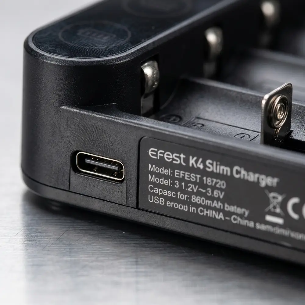 Macro do carregador Slim K4 Efest mostrando logo, textura ABS e porta USB-C com micro-reflexos - Vapor Gringo