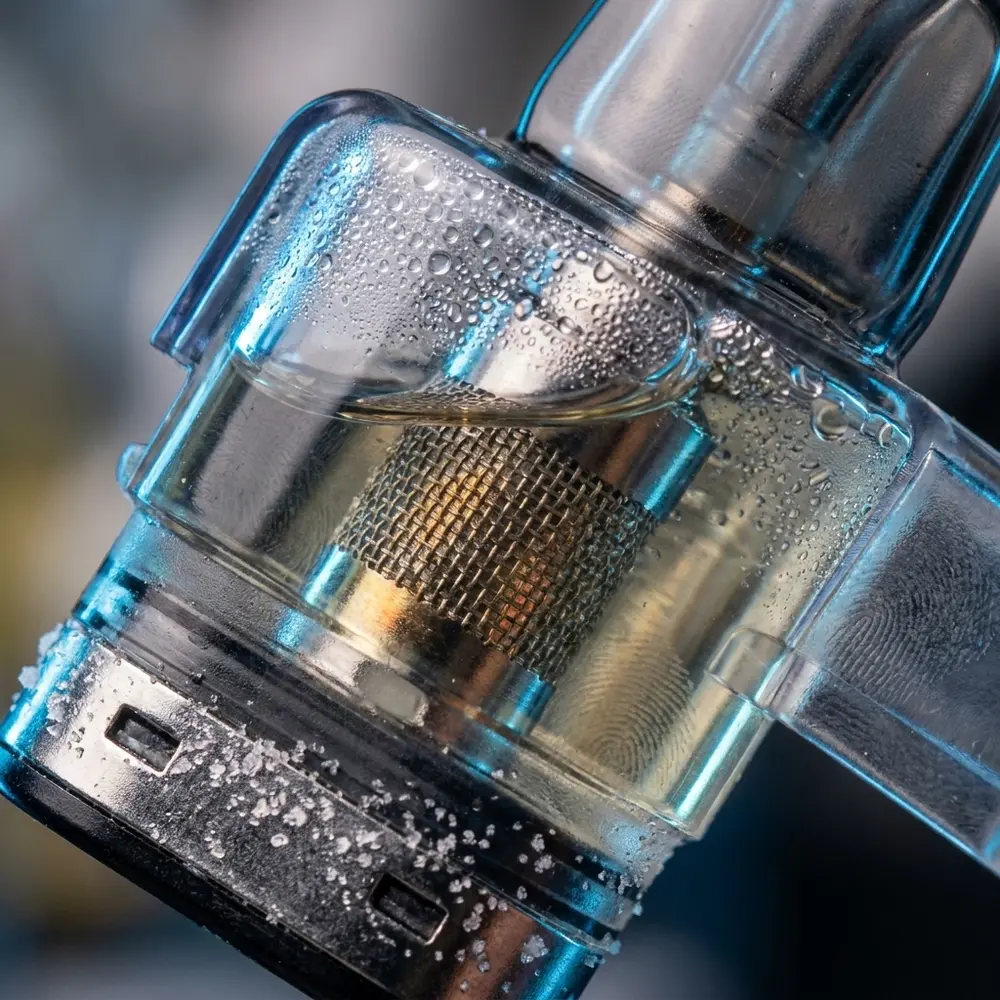 Detalhe do cartucho Elf Bar EW9000 Mango Peach Ice mostrando capsula transparente, metal e gotas de condensacao - Vapor Gringo
