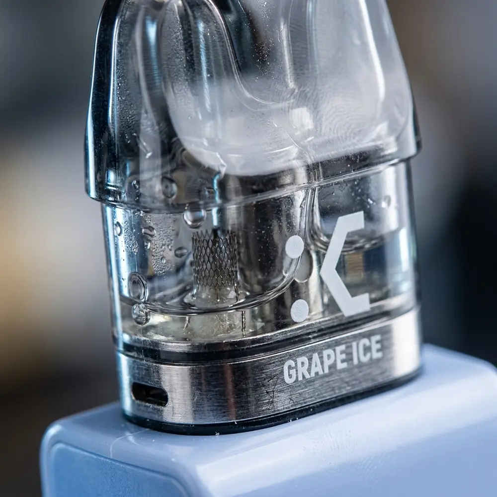 Macro do Cartucho Pod Elf Bar EW9000 Grape Ice mostrando conector metalico, malha interna e gotas de condensacao - Vapor Gringo