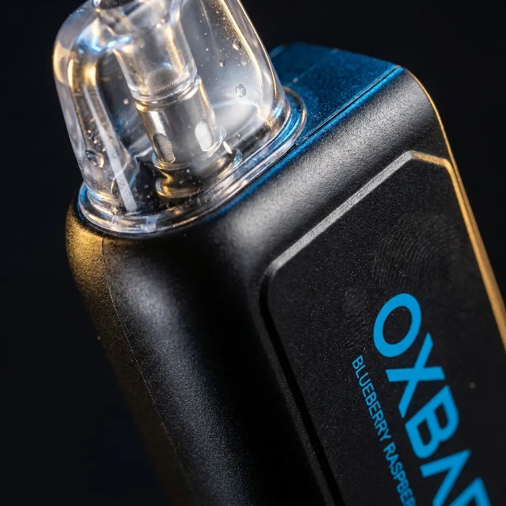 Macro do cartucho refil Oxbar G32K mostrando transparência, seções metálicas e condensacao na superfície - Vapor Gringo