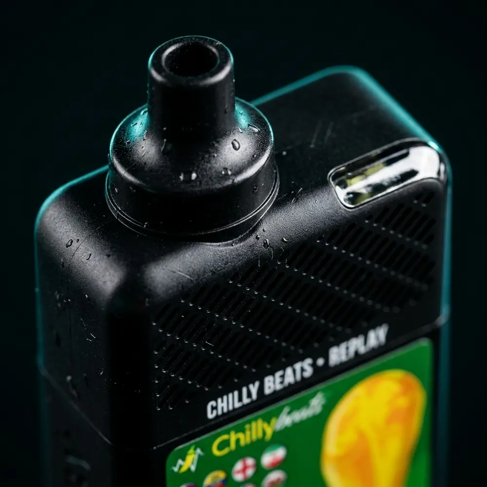 Macro do Chilly Beats Replay mostrando ponta, rótulo e gotas de condensação com reflexos metálicos - Vapor Gringo