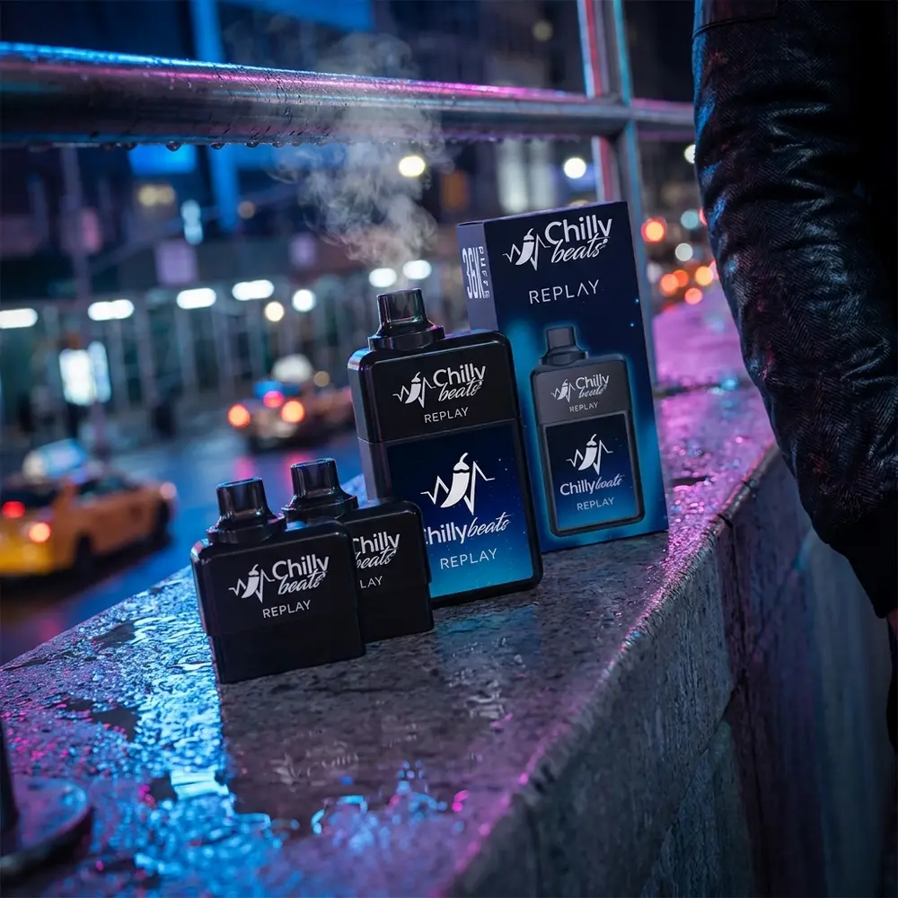 Chilly Beats Replay apoiado em parapeito molhado com reflexos neon urbanos e fundo de rua desfocado - Vapor Gringo