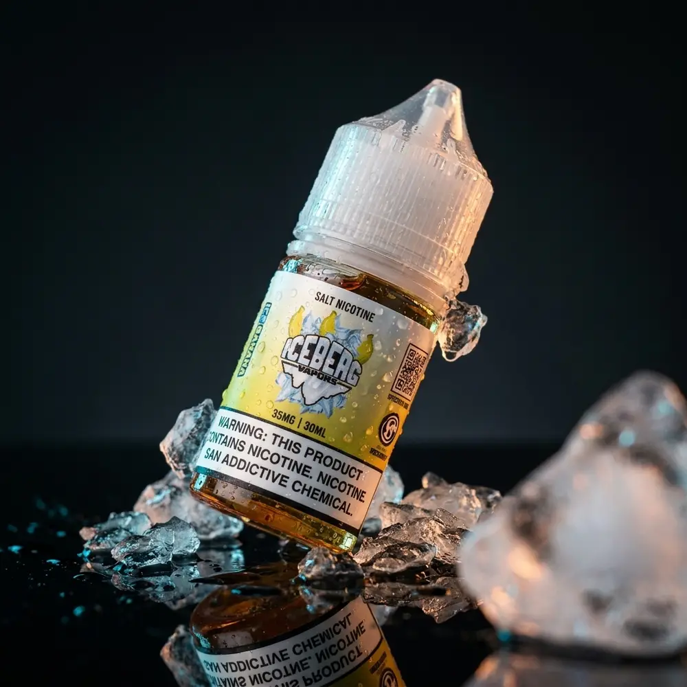 Frasco Iceberg Vapors Salt Ice Banana suspenso sobre base acrílica com gelo e gotas de condensação - Vapor Gringo