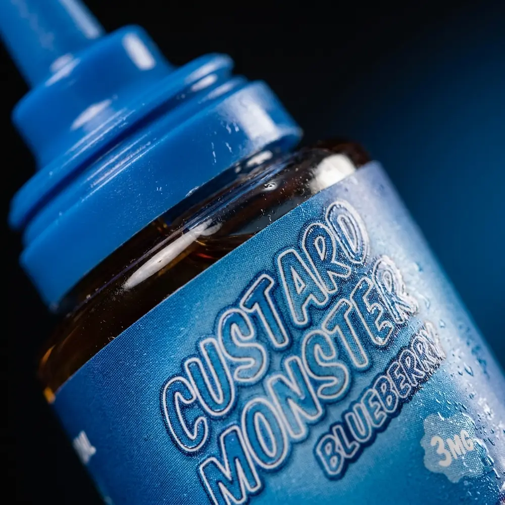 Rótulo e bico do Líquido Jam Monster Blueberry Custard com gotas de condensação e textura do rótulo em detalhe. - Vapor Gringo