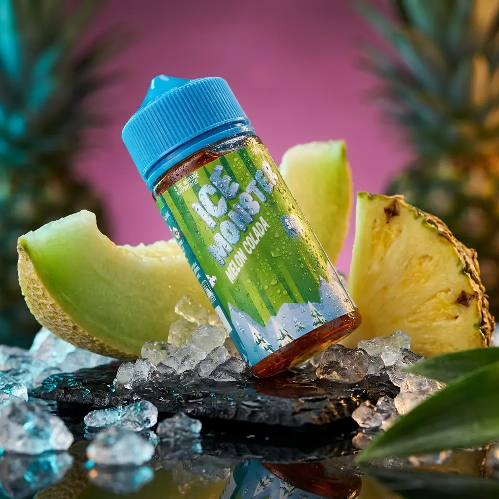 Garrafa Jam Monster Ice Melon Colada sobre pedra preta molhada com gelo e fatias de melão, iluminação cinematica - Vapor Gringo