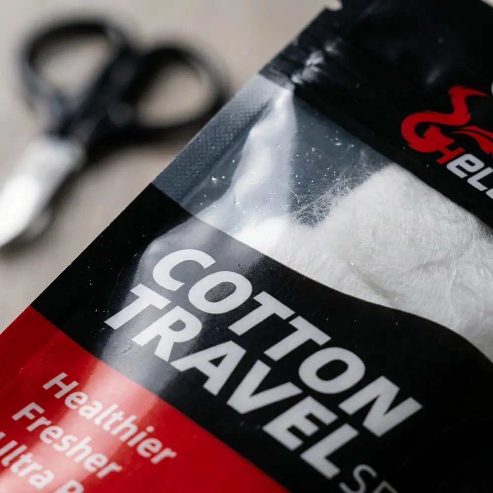 Detalhe macro do Kit Algodão Cotton Travel Set Hellvape mostrando selo, etiqueta e fibras do algodão - Vapor Gringo