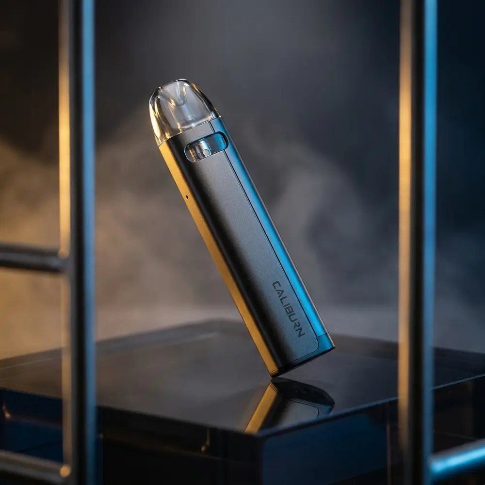 Kit Pod Caliburn A2s da Uwell sobre base acrilica escura com luzes dramáticas e reflexos marcantes - Vapor Gringo