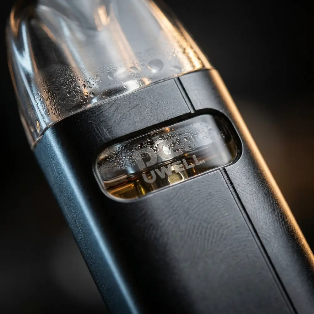 Close-up do Caliburn A2s mostrando acabamento em liga de alumínio, janela do pod e gotículas de condensacao - Vapor Gringo