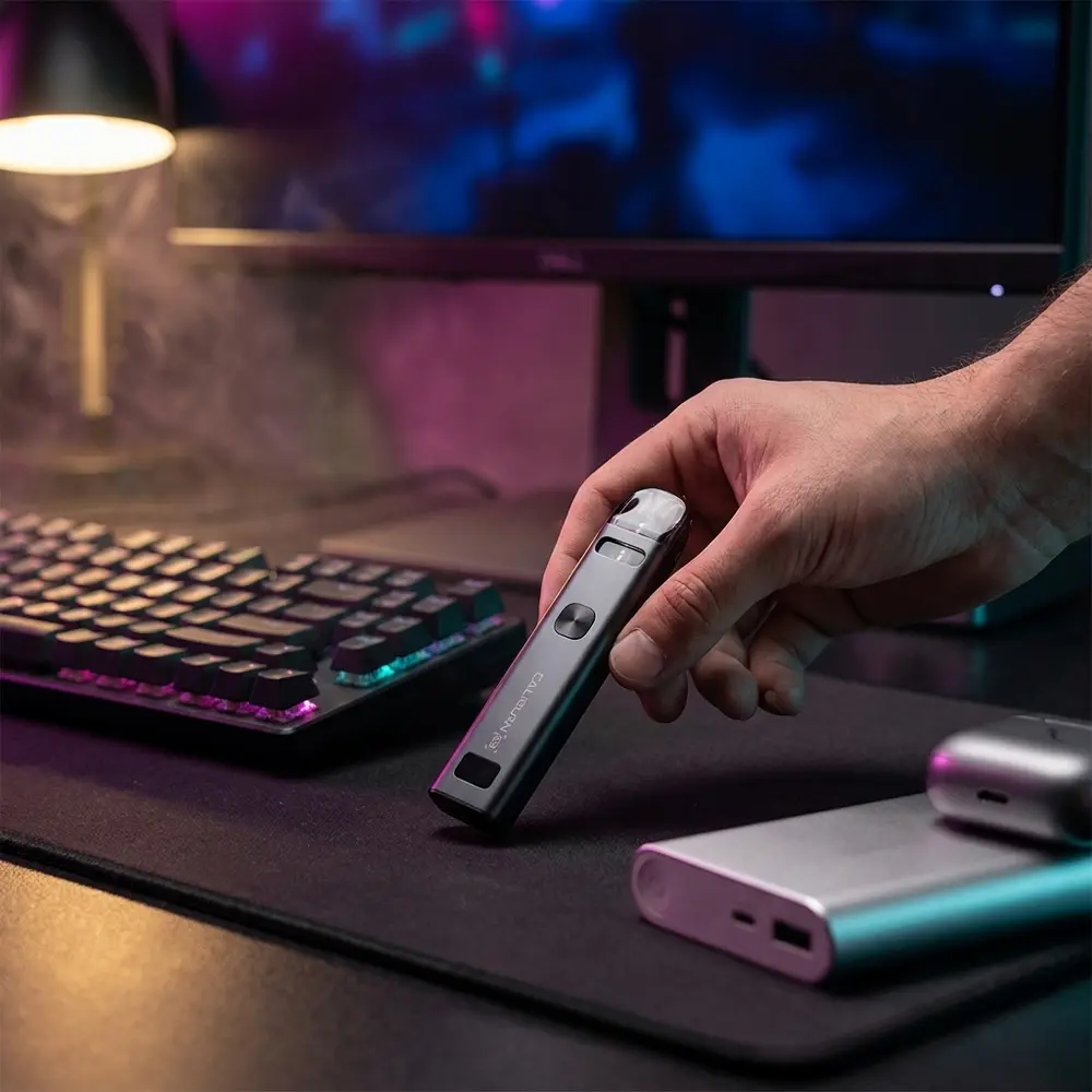 Kit Pod Caliburn G3 sobre mesa gamer RGB, perto de teclado mecanico e monitor com luzes noturnas - Vapor Gringo