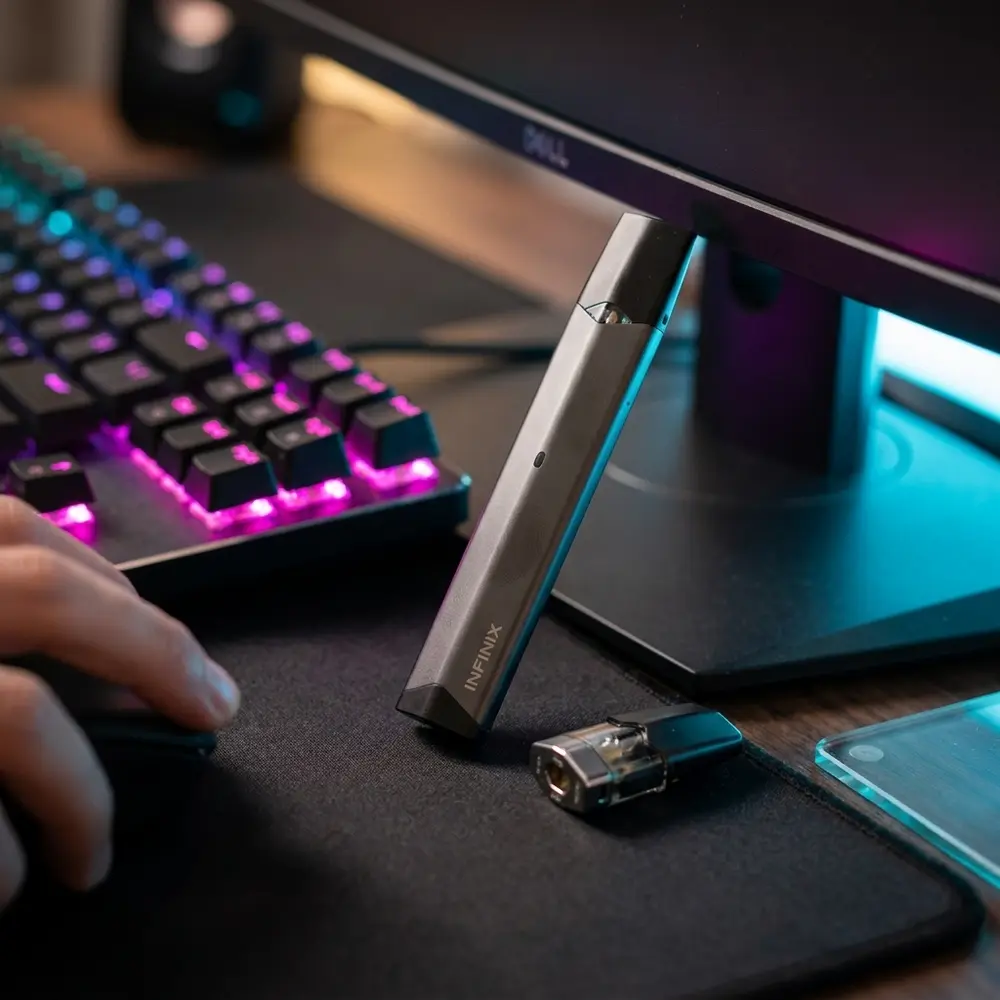 Kit Pod Infinix Smok apoiado em mousepad RGB de setup gamer com teclado iluminado ao fundo - Vapor Gringo