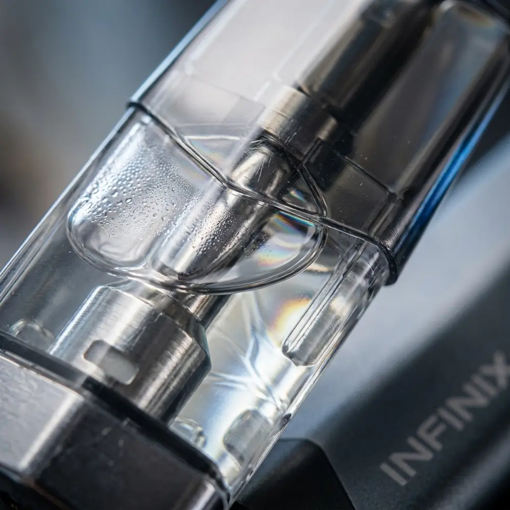 Detalhe do cartucho Infinix Smok mostrando transparencia, secao metalica e gotas de condensacao - Vapor Gringo