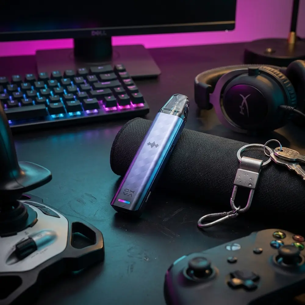 Kit Pod Xlim SE 2 Oxva sobre mesa gamer com teclado RGB e luzes azuis e magenta ao fundo - Vapor Gringo