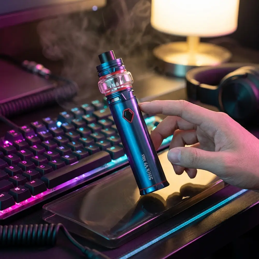 Kit Stick V9 Max SMOK sobre mesa gamer RGB, reflexos magenta-ciano e acessórios de jogo ao redor - Vapor Gringo