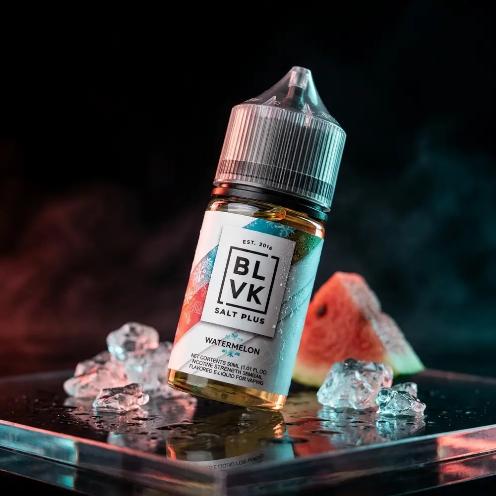 Garrafa BLVK Salt Plus Watermelon Ice sobre vidro preto molhado com gotas e luzes vermelhas e azuladas - Vapor Gringo
