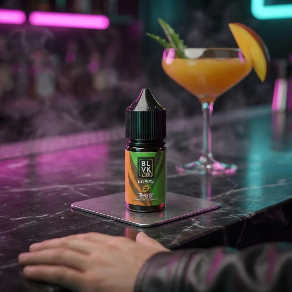 Garrafa do liquido Blvk Unicorn Salt Aloe Mango sobre balcão noturno com neon desfocado e fatia de manga - Vapor Gringo