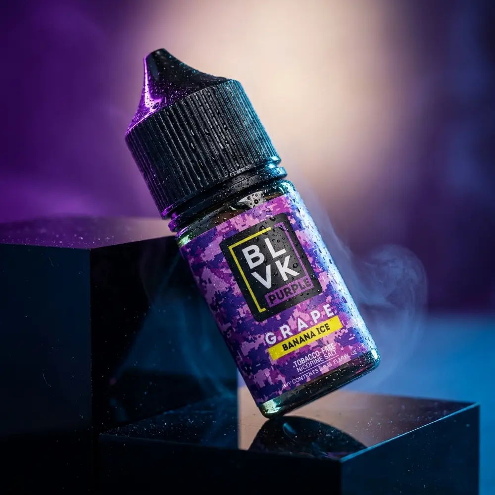 Frasco Líquido Blvk Unicorn Salt Grape Banana Ice sobre acrílico com condensação e luzes roxas - Vapor Gringo