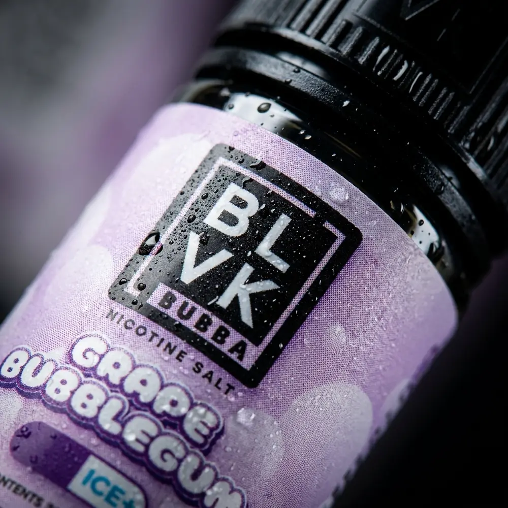 Close-up do rotulo BLVK Unicorn Salt Grape Bubblegum Bubba com gotas de condensacao e reflexos precisos - Vapor Gringo