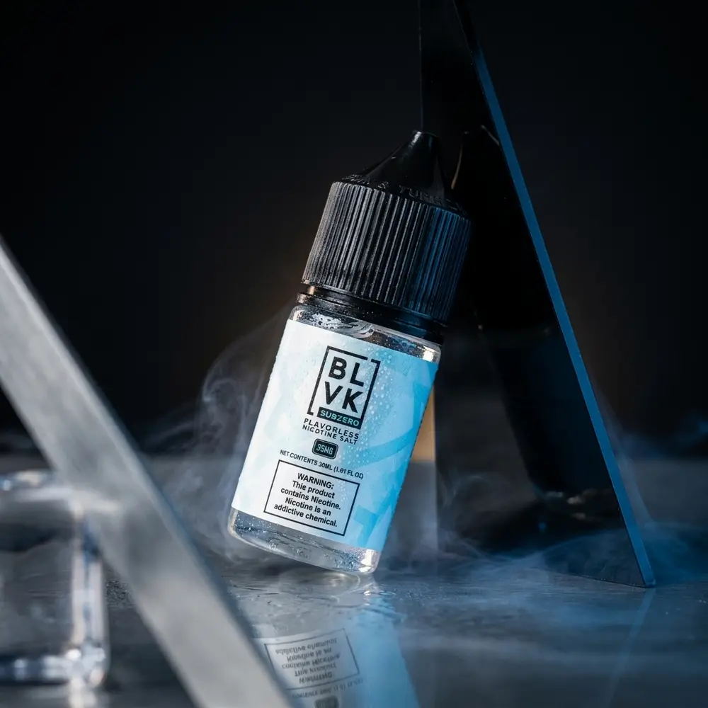 Frasco BLVK Unicorn Salt SubZero sem sabor sobre acrílico molhado com iluminação azul e prata. - Vapor Gringo