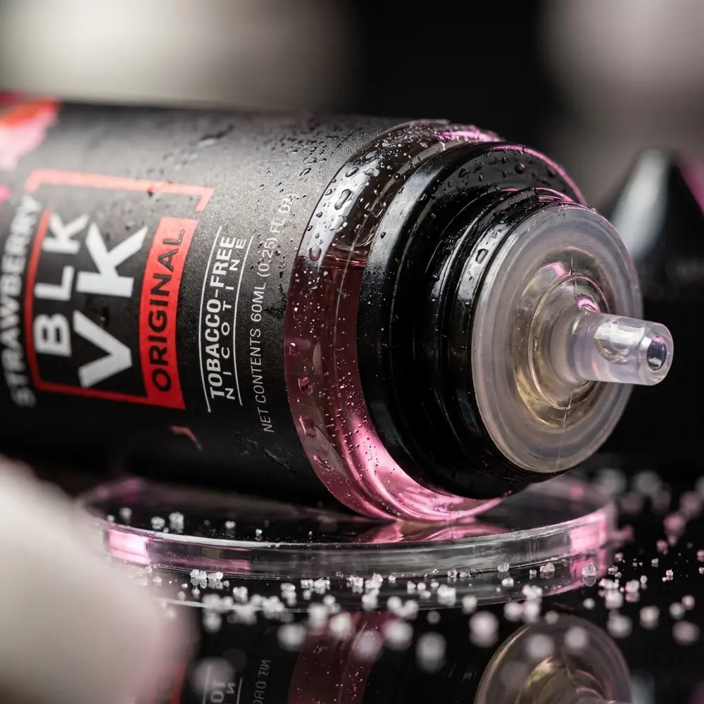 Close-up do rótulo Blvk Unicorn Strawberry Candy com gotas de condensação e reflexos nítidos no bico - Vapor Gringo