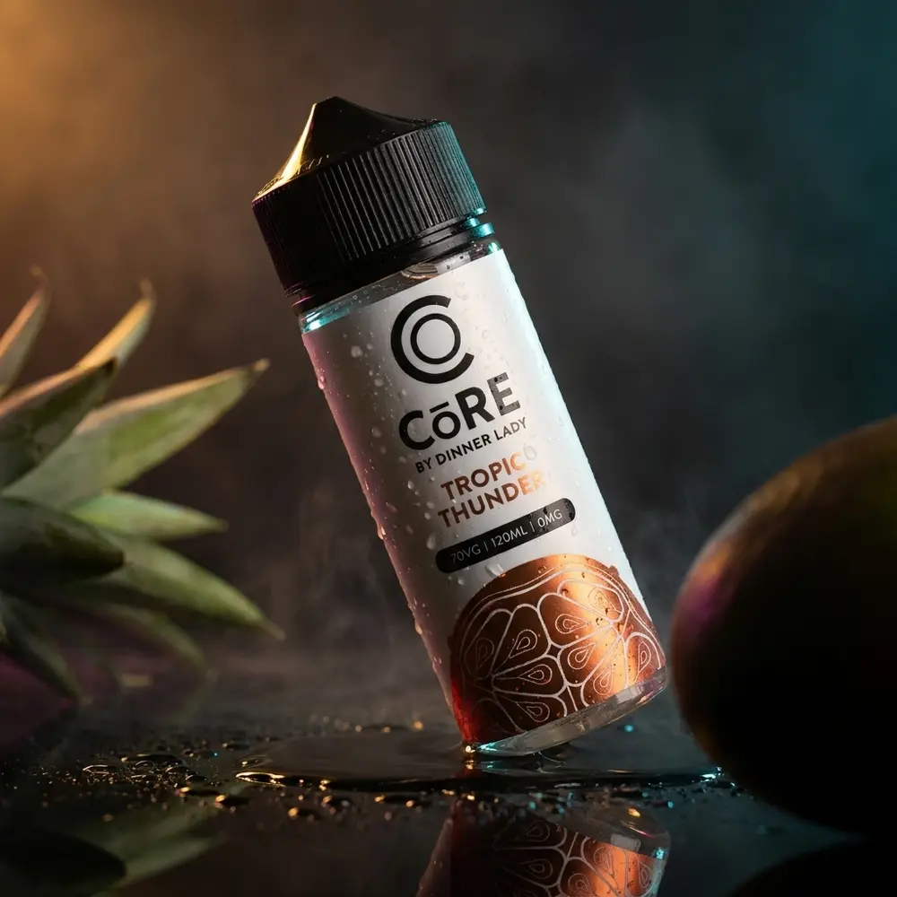 Líquido Core by Dinner Lady Tropic Thunder 120ml sobre base acrílica escura com reflexos neon e frutas em desfoque - Vapor Gringo