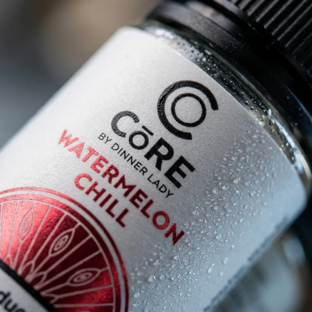 Macro do rótulo do Líquido Core Watermelon Chill com condensação, detalhe do vidro e reflexos frios - Vapor Gringo
