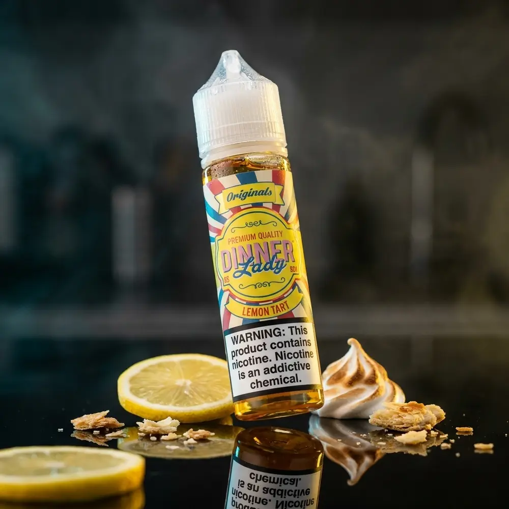 Frasco de Líquido Dinner Lady Lemon Tart 60ml sobre acrílico preto com fatia de limão e luzes amarelas - Vapor Gringo