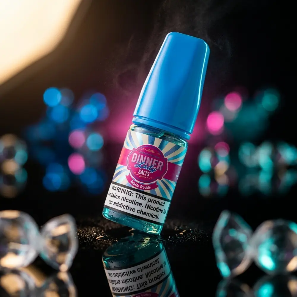 Garrafa 30ml Dinner Lady Salt Bubble Trouble sobre acrilico preto, reflexos magenta e teal e fundo desfocado - Vapor Gringo