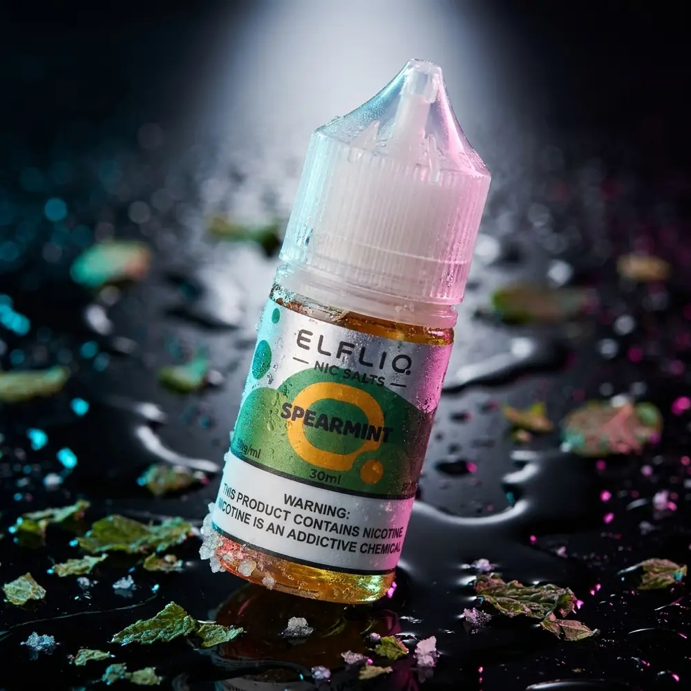 Garrafa Líquido Elf Liq Salt Spearmint sobre acrílico preto molhado com folhas de hortelã e iluminação dramática - Vapor Gringo