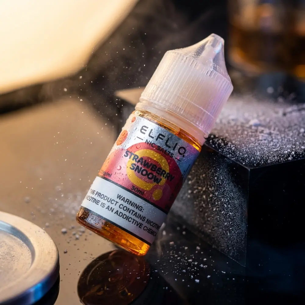 Garrafa Líquido Elf Liq Salt Strawberry Snow sobre acrílico preto com luzes azul-magenta e gotas de gelo - Vapor Gringo