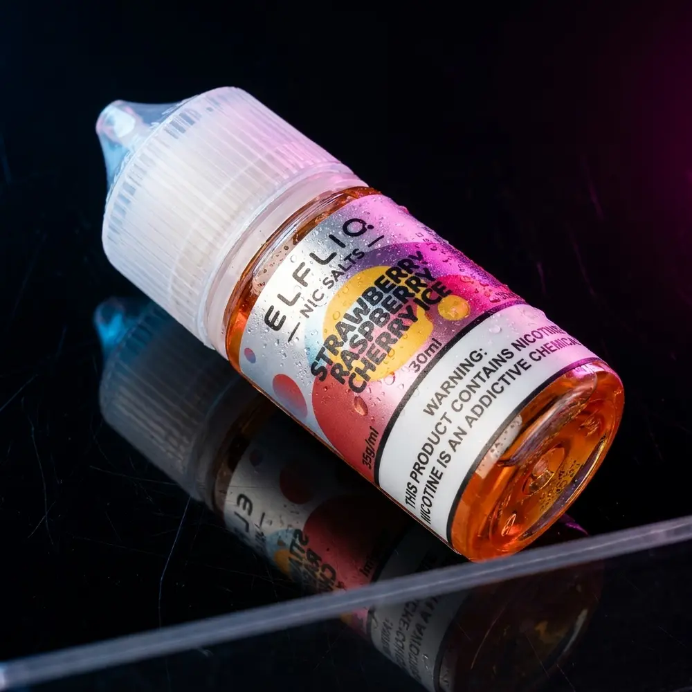 frasco do liquido Elf Liq Salt Strawberry Raspberry Cherry Ice sobre superficie preta brilhante com gotas e reflexos frios - Vapor Gringo