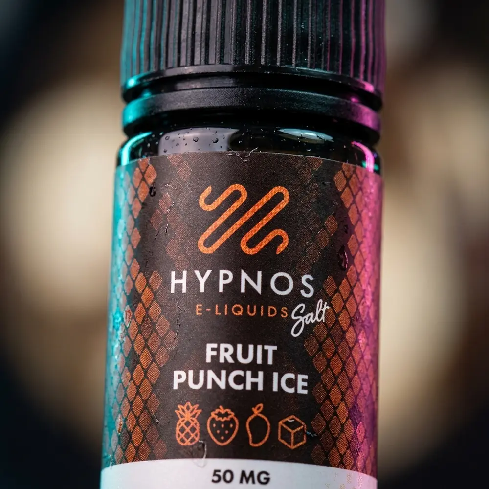 Detalhe macro do rótulo e do bico do Hypnos Salt Fruit Punch Ice com gotas e textura do plástico - Vapor Gringo