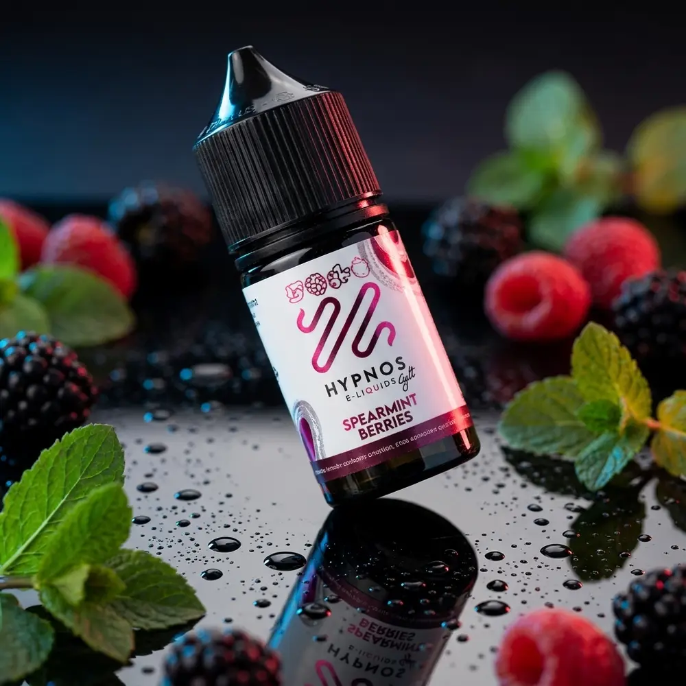 Frasco Líquido Hypnos Salt Spearmint Berries sobre acrílico molhado com folhas de menta e frutas vermelhas, luzes azul e vermelha - Vapor Gringo