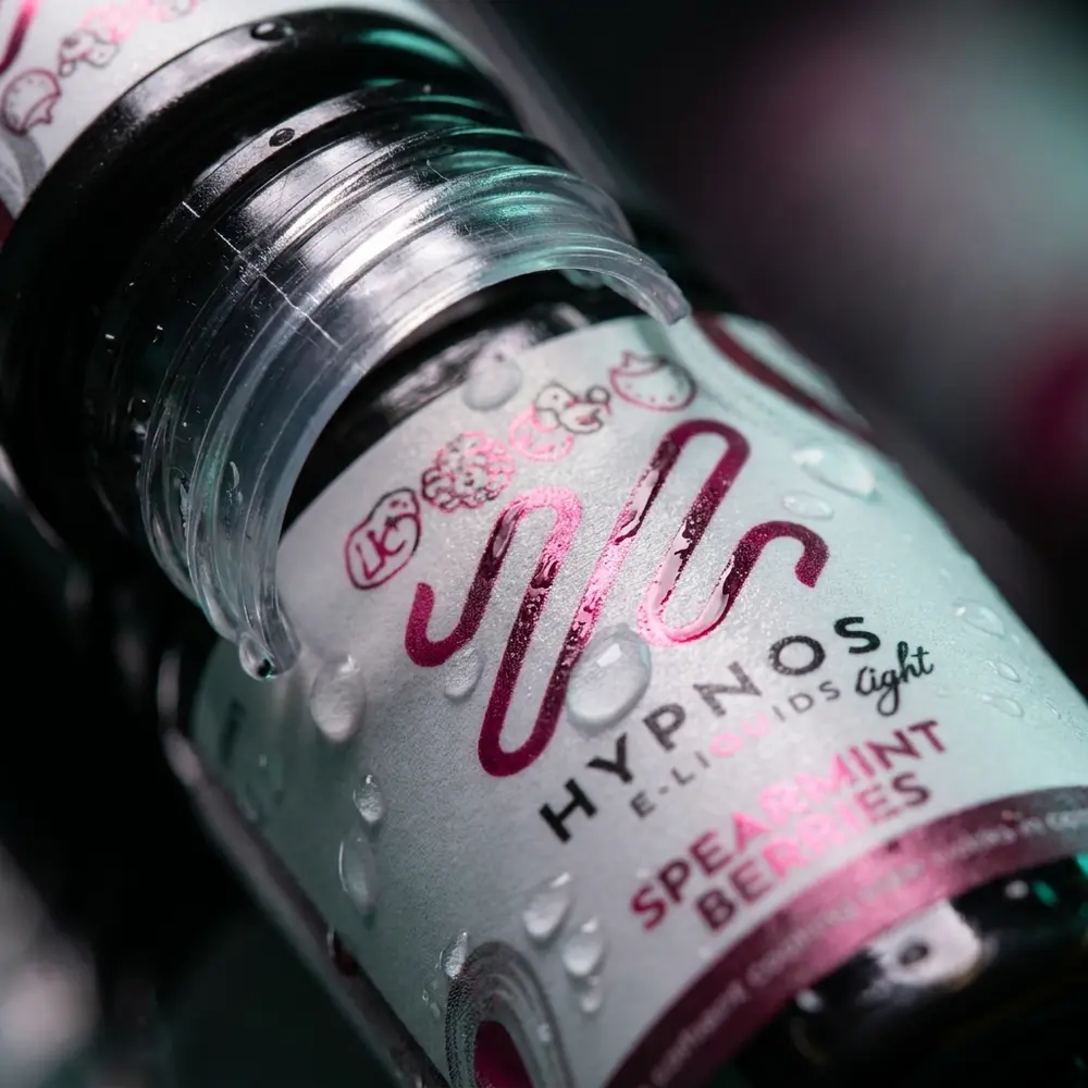 Macro do rótulo e do bico do Líquido Hypnos Salt Spearmint Berries com gotas de condensação e reflexos - Vapor Gringo